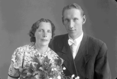 Porträtt av ett brudpar; en herre och en dam. Ateljefoto.