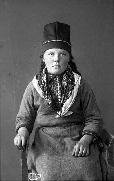 Porträtt av en dam i samedräkt. Ateljefoto.