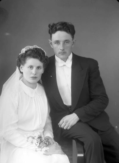 Porträtt av ett brudpar; en herre och en dam. Ateljefoto.