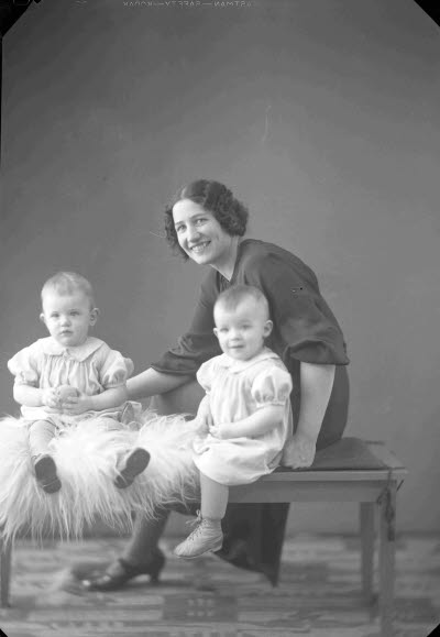 Porträtt av en dam och två barn. Ateljefoto.