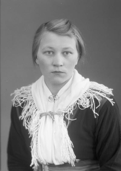 Porträtt av en ung dam i samedräkt. Ateljefoto.