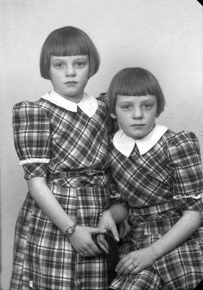 Porträtt av två barn, flickor. Ateljefoto.