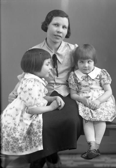 Porträtt av en dam och två barn, flickor. Ateljefoto.