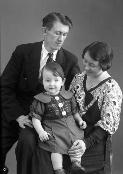 Porträtt av en herre och en dam med ett barn. Ateljefoto.