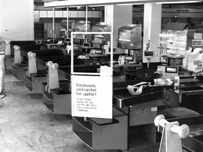 Interiör, Tempo. Kassor. Anslag: "Varuhusets verksamhet har upphört".