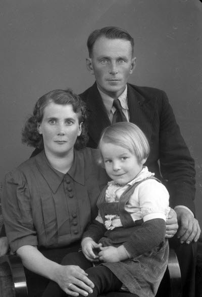 Porträtt av en herre och en dam med ett barn. Ateljefoto.