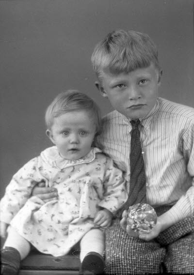 Porträtt av två barn, en flicka och en pojke. Ateljefoto.