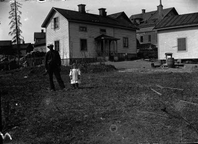En herre och en flicka. Skolgatan, "Husqvarna Lasses" hus. Personer som bott i huset: Fritz Svedberg, Stig Sandström/"Vecko Sandström" (sålde veckotidningar).