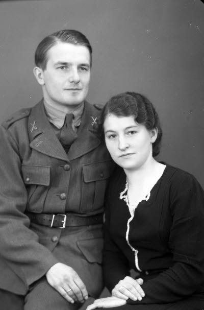 Porträtt av ett par; en herre i militäruniform och en dam. Ateljefoto.