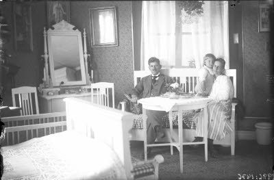 Ett par och ett barn. Hemmiljö; vardagsrum, pigtittare, spegelbyrå.