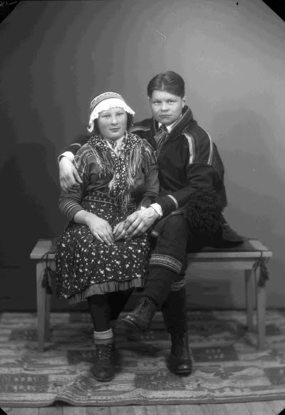 Porträtt av ett par i samedräkter; en dam och en herre. Ateljefoto.