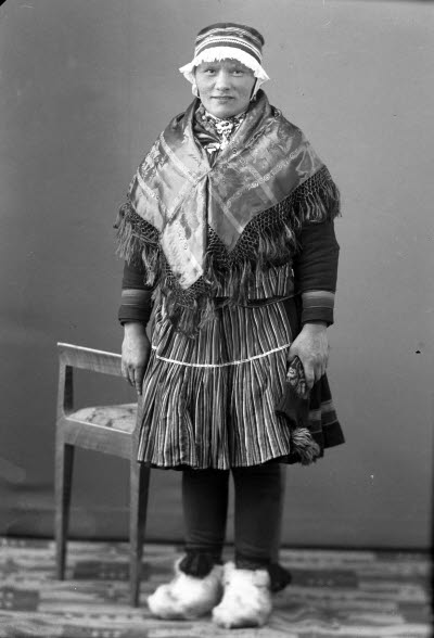 Porträtt av en dam i samedräkt. Ateljefoto.