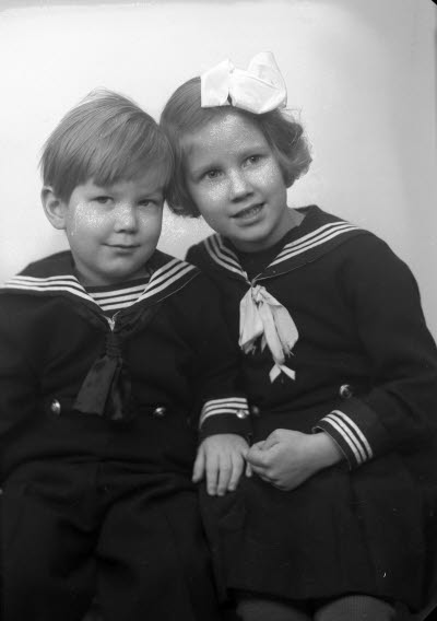 Porträtt av två barn; flicka och pojke. Ateljefoto.