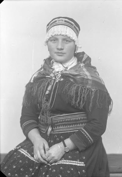 Porträtt av en dam i samedräkt. Ateljefoto.