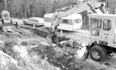 Vägarbete. Traktor, hjulgrävare; grävskopa, personbil med husvagn.