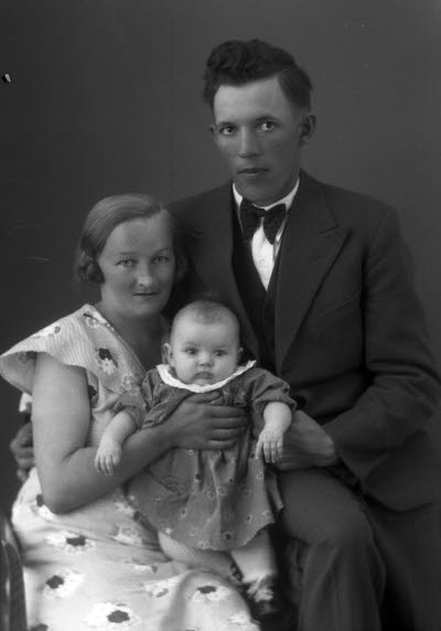 Porträtt av en herre och en dam med ett barn. Ateljefoto.