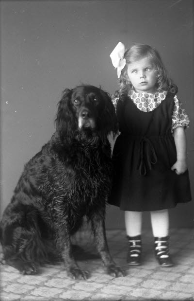 Porträtt av ett barn, flicka med hund. Ateljefoto.