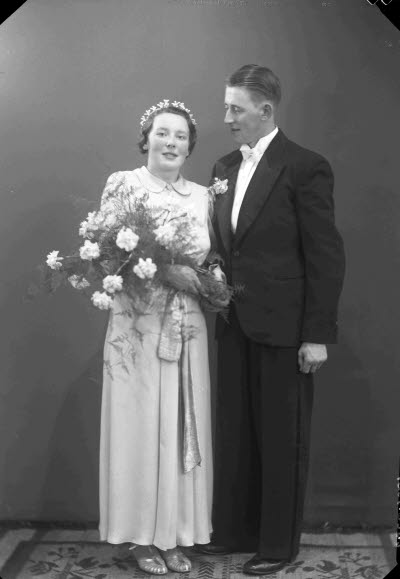 Porträtt av ett brudpar; en herre och en dam. Ateljefoto.