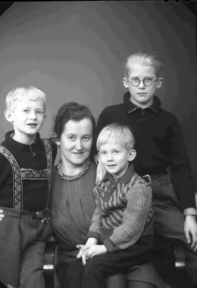 Porträtt av en dam och tre barn, pojkar; mor och barn. Ateljefoto.