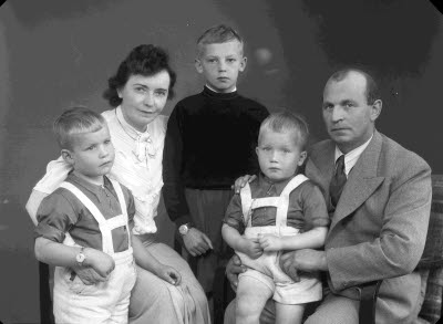 Porträtt av en herre och endam med tre barn, pojkar. Ateljefoto.