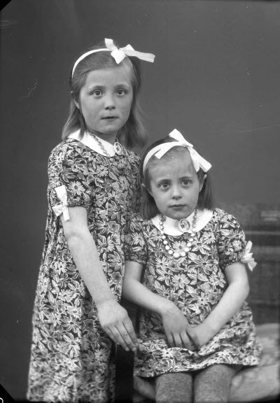 Porträtt av två barn, flickor. Ateljefoto.