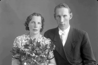 Porträtt av ett brudpar; en herre och en dam. Ateljefoto.