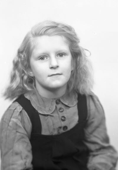 Porträtt av ett barn; en flicka. Ateljefoto.