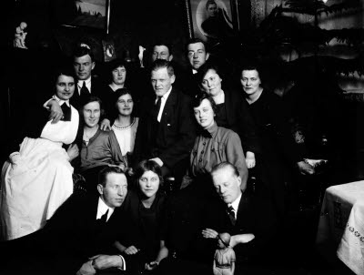 Sällskap i hemmiljö; vardagsrum, interiör. Oidentifierade.