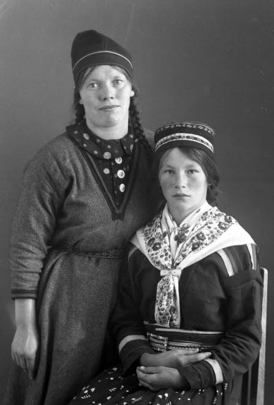 Porträtt av två damer i samedräkter. Ateljefoto.