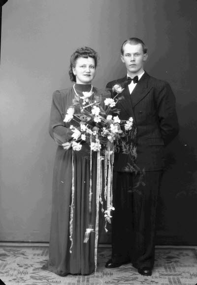 Porträtt av ett brudpar; en herre och en dam. Ateljefoto.