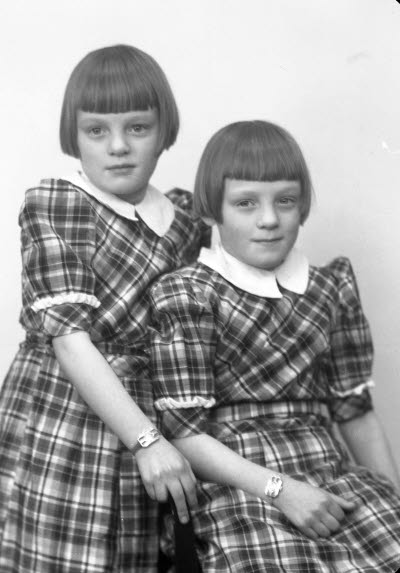 Porträtt av två barn, flickor. Ateljefoto.