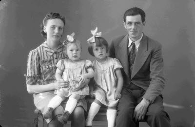 Porträtt av en herre och en dam med två barn, flickor. Ateljefoto.