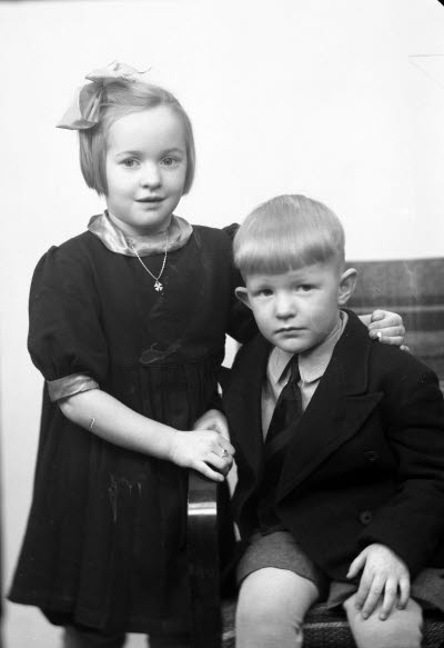 Porträtt av två barn, en flicka och en pojke. Ateljefoto.