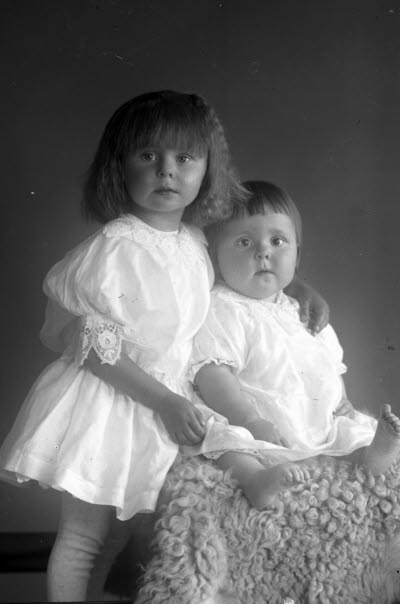 Porträtt av 2 barn, flicka. Ateljefoto.