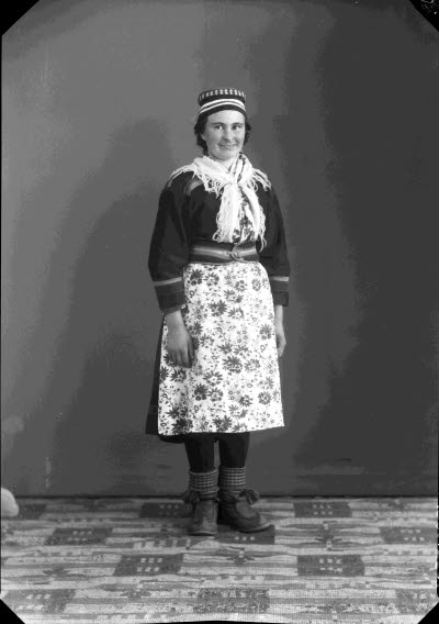 Porträtt av en dam i samedräkt. Ateljefoto.