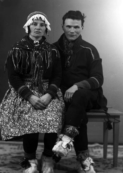 Porträtt av ett par i samedräkter; en herre och en dam. Ateljefoto.