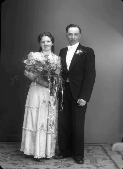 Porträtt av ett brudpar; en herre och en dam. Ateljefoto.