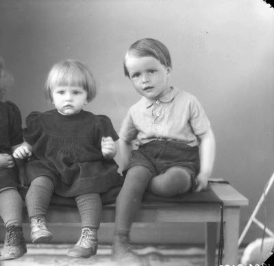 Porträtt av två barn, flicka, pojke. Ateljefoto.