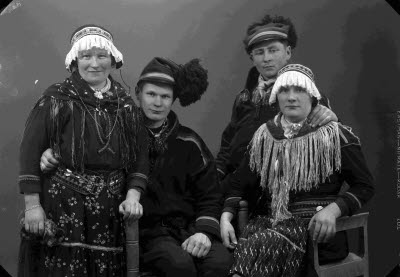 Porträtt av två herrar och två damer i samedräkter. Ateljefoto.