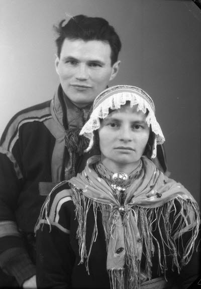 Porträtt av ett par i samedräkter; en herre och en dam. Ateljefoto.