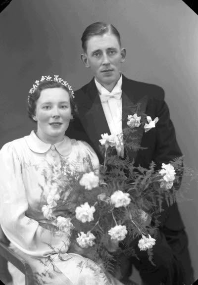 Porträtt av ett brudpar; en herre och en dam. Ateljefoto.