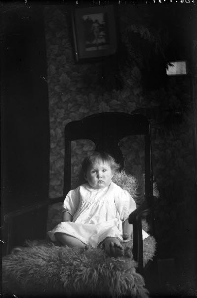 Ett barn. Liten flicka i hemmiljö. Vardagsrum.