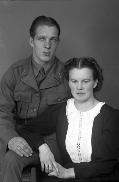 Porträtt av ett par; en herre i militäruniform och en dam. Ateljefoto.