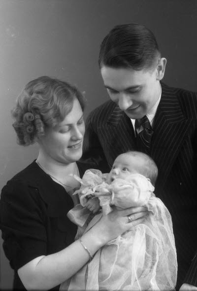 Porträtt av en herre och en dam med ett barn. Ateljefoto.