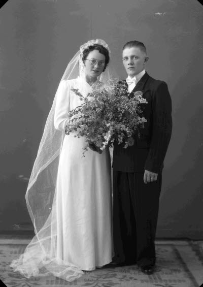 Porträtt av ett brudpar; en herre och en dam. Ateljefoto.