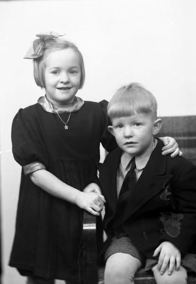 Porträtt av två barn, en flicka och en pojke. Ateljefoto.