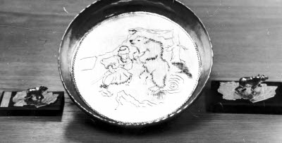 Tenntallrik design Lars Pirak. Tennsmide. Gravyr.