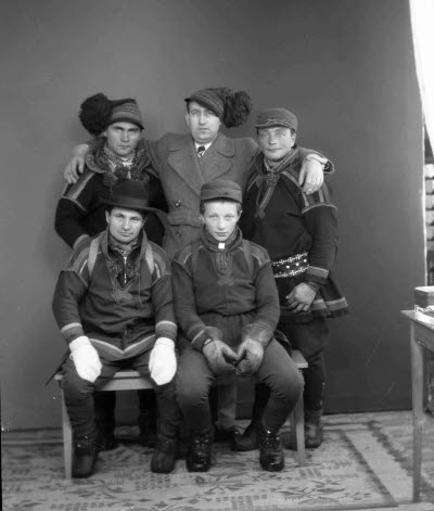 Porträtt av fem herrar, varav fyra i samedräkter. Ateljefoto.