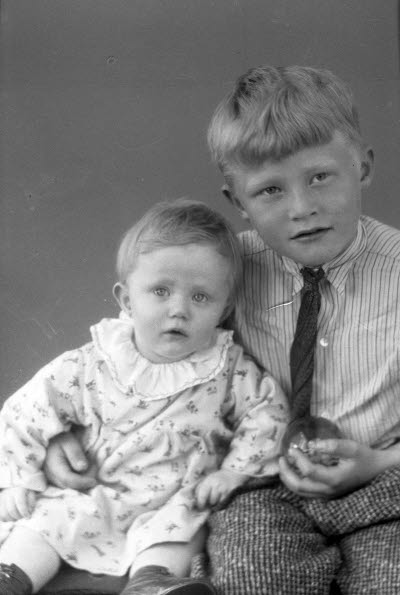 Porträtt av två barn, en flicka och en pojke. Ateljefoto.