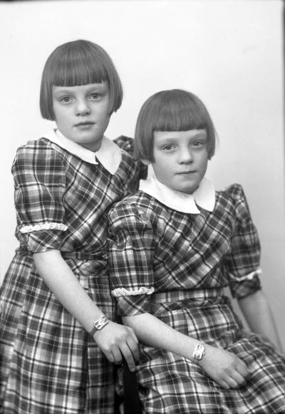 Porträtt av två barn, flickor. Ateljefoto.